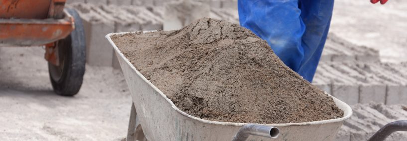 african man brick manufacturing wheelbarrow , made from cement concrete and sand